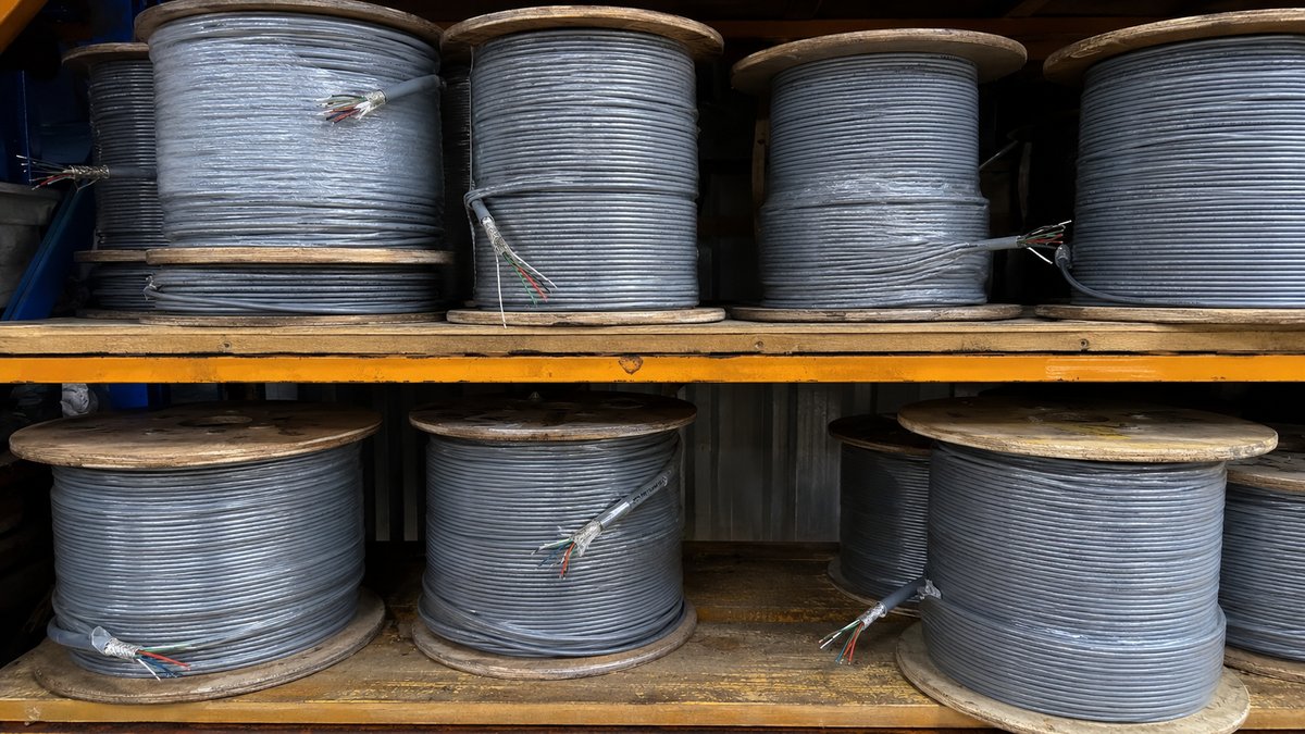 Reels of screened instrumentation cable in various pair counts on a warehouse shelf