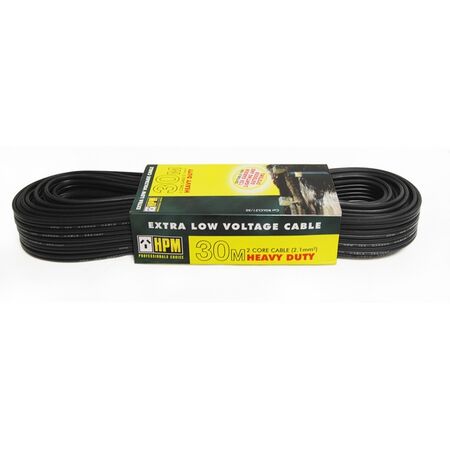 Black 12V low voltage garden lighting cable running along a garden bed edge toward path lights in an Australian backyard